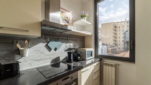 A modern kitchen with a window, a microwave, a kettle, and a toaster. - GuestHost - Modern and bright apartment of 60 sqm, able to accommodate up to 2 people, located on the second floor of a building without a lift (NOT suitable for disabled people).The property is located in an area well connected by public transport, just (Roma)