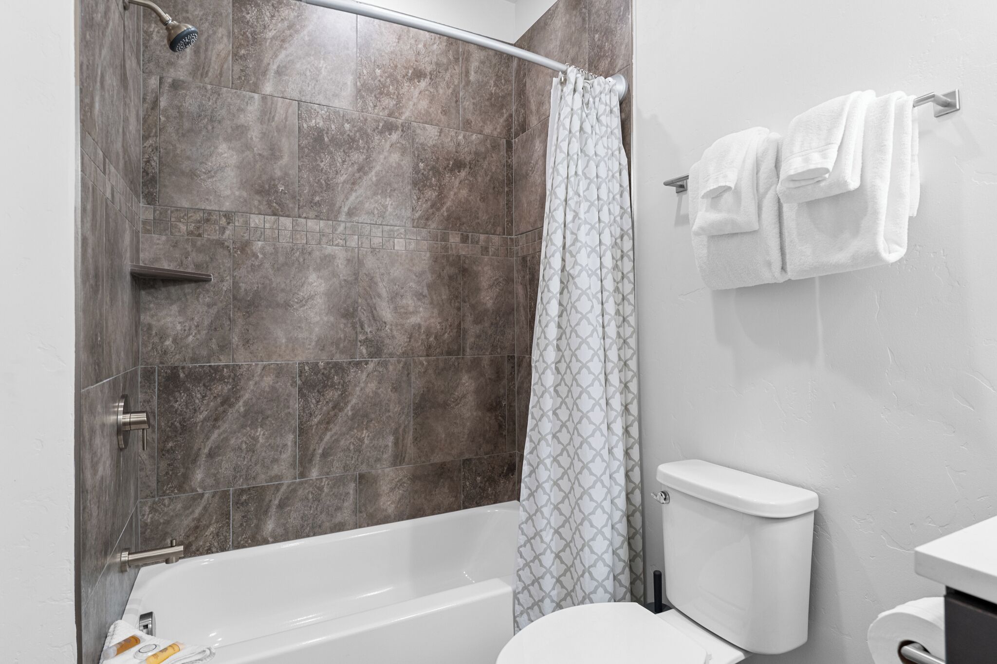 A modern bathroom with a shower, toilet, and bathtub.