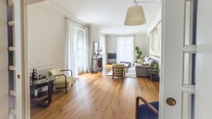 A spacious living area with a fireplace, a sofa, a chair, and a dining table. - Dimora Adriani on the Noble Floor, Charm & Relax in the Heart of Langhe (Cherasco)
