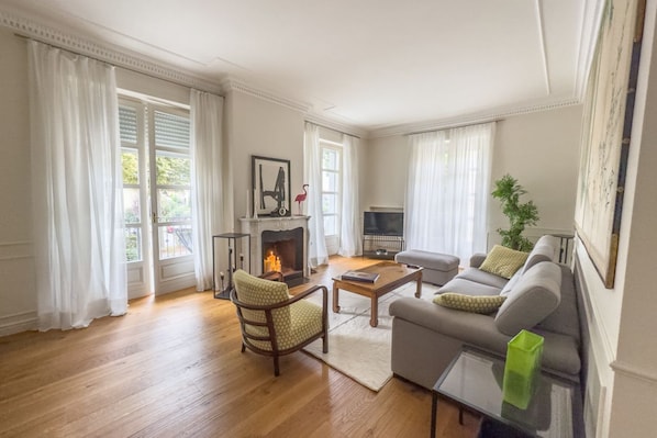 A living room with a fireplace, a sofa, a coffee table, and a television.