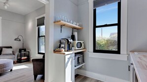 Une cuisine moderne équipée d’un four à micro-ondes encastré, d’une machine à café et d’une étagère à verres.