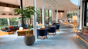 Un vaste espace intérieur doté de hauts plafonds, de grandes fenêtres et de mobilier moderne.