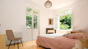 Une chambre à coucher comprenant un lit, une chaise, une commode et une fenêtre donnant sur un paysage verdoyant.