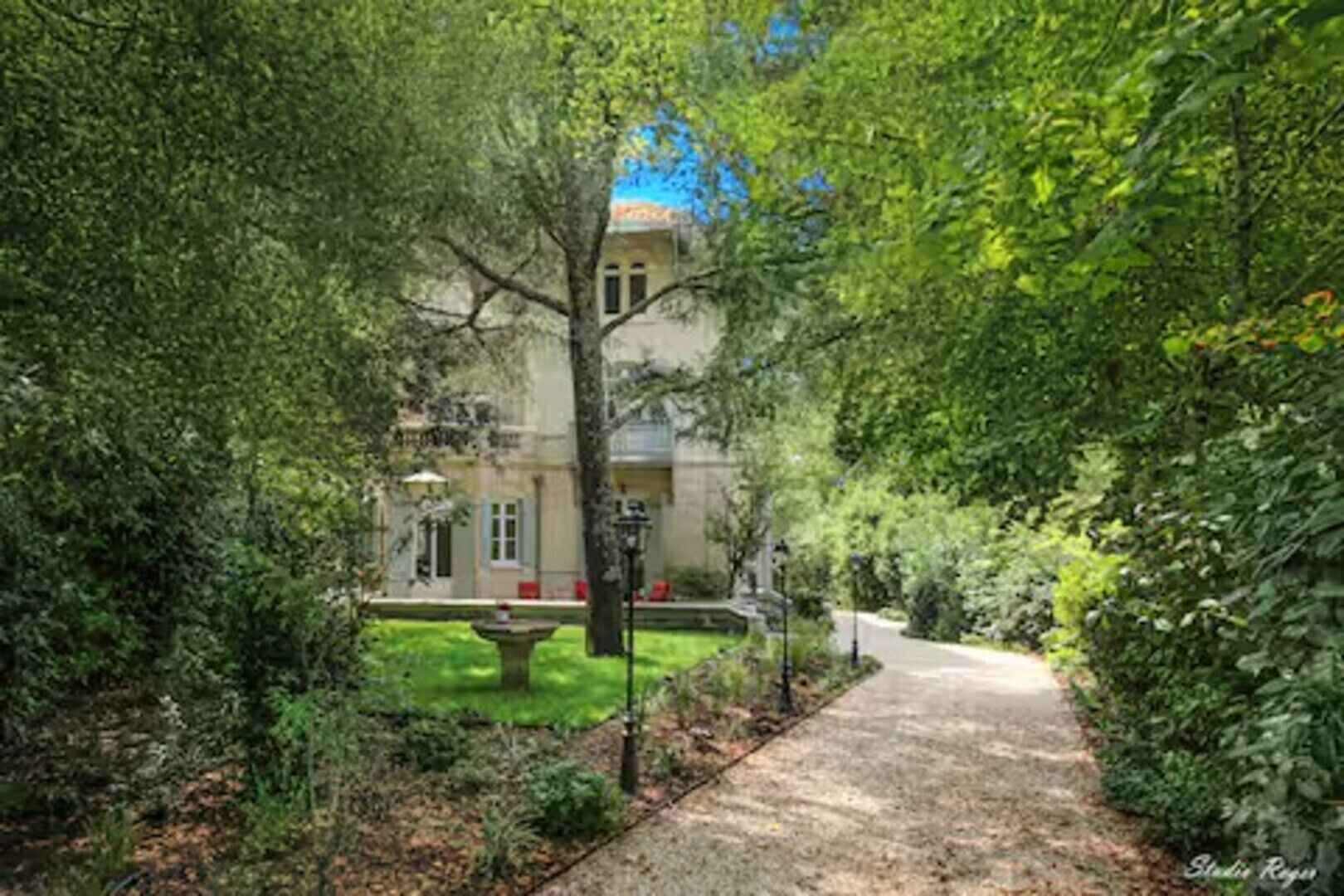 Un chemin menant à un bâtiment entouré d’une végétation luxuriante.