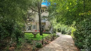 Un chemin menant à un bâtiment entouré d’une végétation luxuriante.