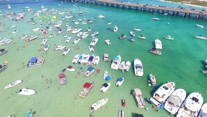 Un port de plaisance où de nombreux bateaux sont amarrés et où l’on peut voir des gens sur la plage.