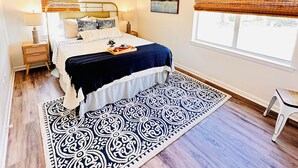 A bedroom with a bed, bedside tables, a ceiling fan, a window with blinds, and a patterned rug. - Charming 2-bedroom house in Ardmore with AC, WiFi. Enjoy your stay (Ardmore)