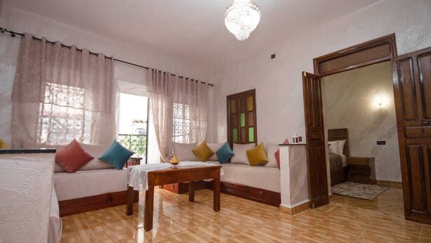 Una sala de estar con un sofá, una mesa de madera y una araña.