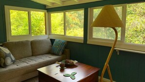 Une pièce chaleureuse avec un canapé, une table basse en bois et un lampadaire.