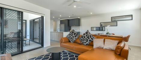 A modern living room with a leather sofa, a coffee table, and a patterned rug.