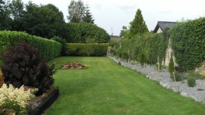 A well-maintained garden with a neatly trimmed lawn, a flower bed, and various shrubs. - The Railway Lodge, 4 Bedrooms, Sleeps 11, Pets Ok (Moate)