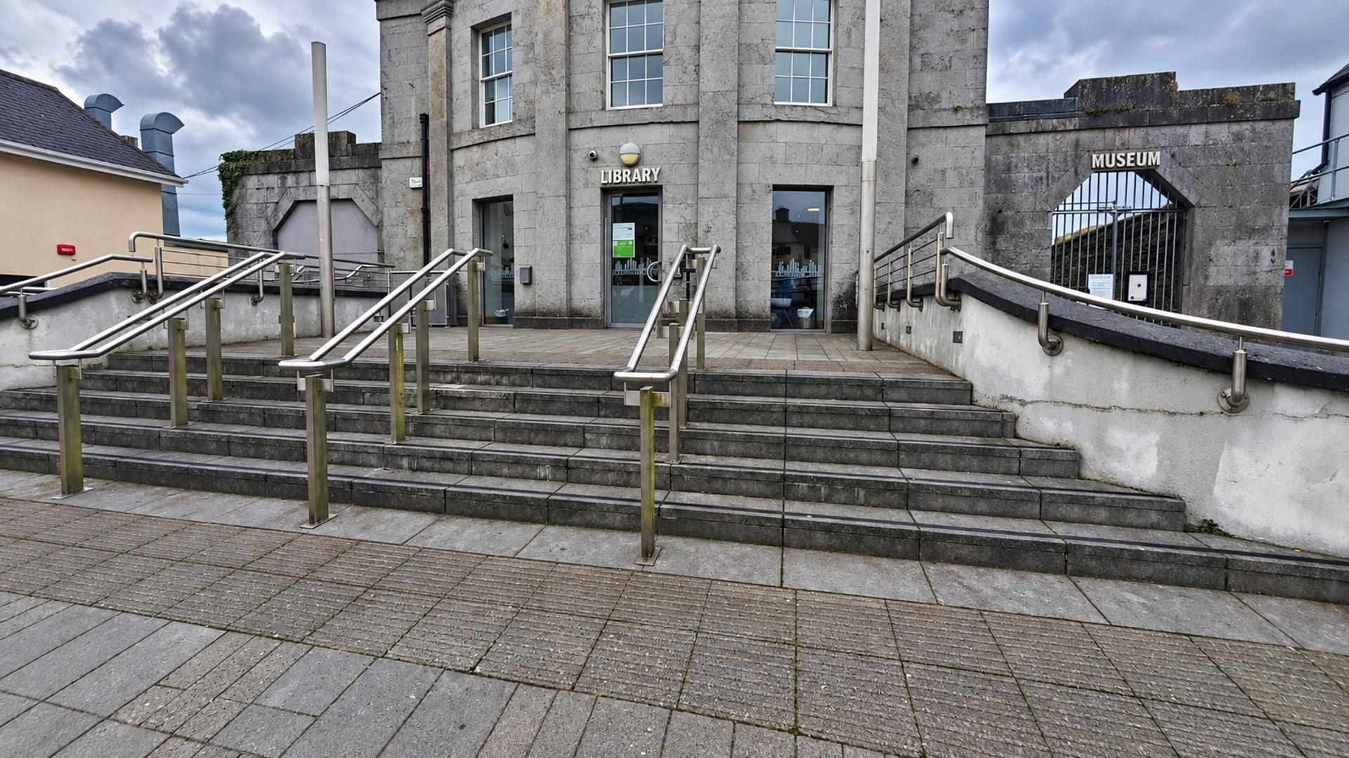 A building with a staircase leading to a library and museum entrance.