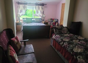 Une chambre à coucher avec un lit, une chaise, un bureau et un téléviseur.