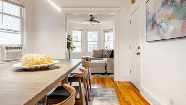 A dining area with a wooden table, chairs, and a plate of food.