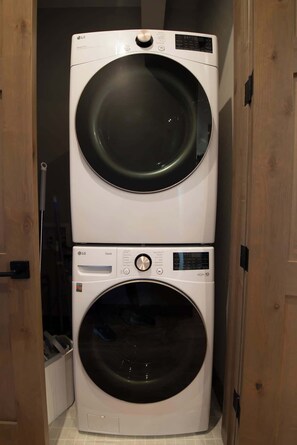 Une machine à laver et un sèche-linge superposés dans une buanderie.