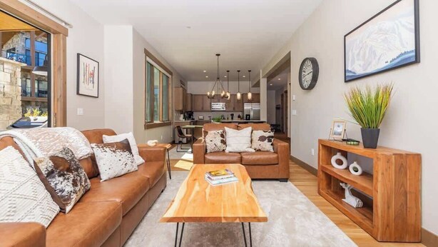 Een moderne woonkamer met een bank, salontafel en een houten bijzettafeltje.