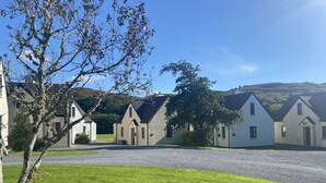 Une rangée de charmantes maisons traditionnelles, avec une allée en gravier et une pelouse verdoyante devant.