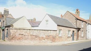 A stone building with a triangular roof and a flat facade. - 1 Bed Cottage - Plus Sofa Bed - Sleeps 4 - Pets (Berwick-upon-Tweed)