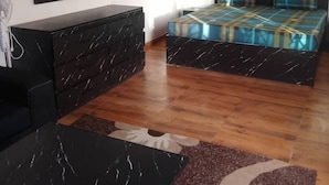 Een slaapkamer met een bed, een dressoir, een televisie en een spiegel.