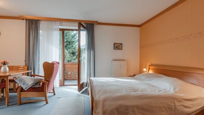 A hotel room with a bed, a desk, a chair, a radiator, and a view of the outdoors. - Schmuckstück by Interhome (Bad Hofgastein)