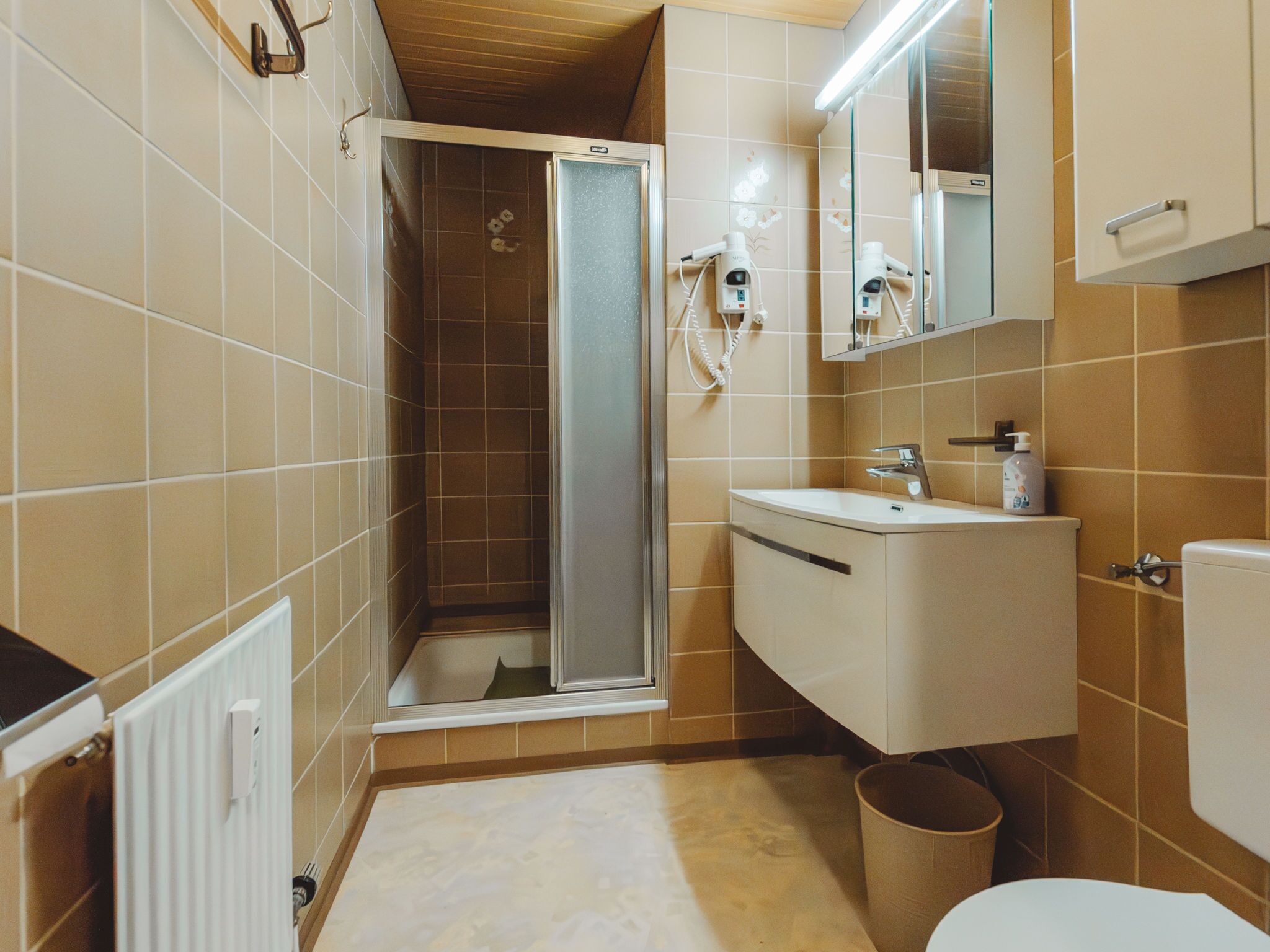 Ein Badezimmer mit Dusche, Waschbecken und Toilette.