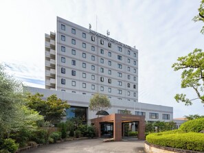 Ein modernes Hotelgebäude mit einer flachen Fassade, zahlreichen Fenstern und einem zentralen Eingang.