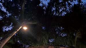 Een openluchtrestaurant met een overdekt zitgedeelte, tafels en hangende lampen.