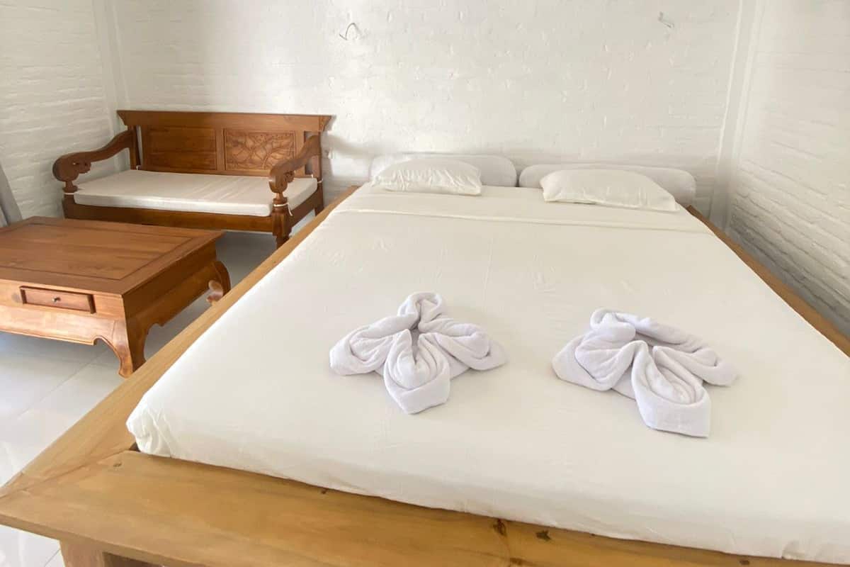 Ein Zimmer mit einem Bett, einer hölzernen Bank und einem Tisch.