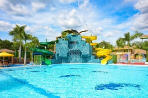 A swimming pool with a water slide and a rock formation. - Kabaleyan Cove Resort powered by Cocotel (San Carlos)