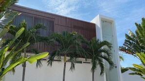 Un edificio moderno con listones verticales de madera y un hueco para ascensor de vidrio.