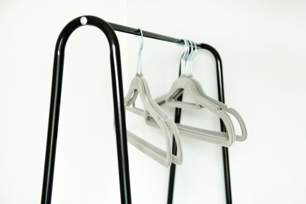 A metal rack with two white hangers.