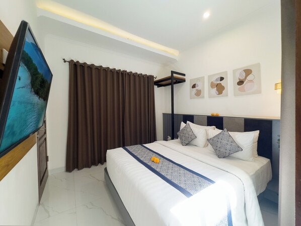 Une chambre d’hôtel équipée d’un lit, de rideaux, d’un téléviseur à écran plat et d’œuvres d’art murales.