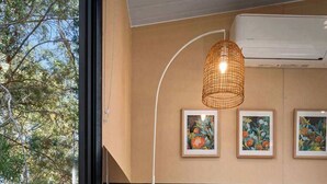 A modern bedroom with a large bed, a hanging light fixture, and framed artwork on the wall. - Manna Gum Retreat by Tiny Away (Cudgee)