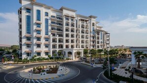 A multi-story hotel with a central courtyard, balconies, and a roundabout.