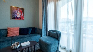 Un salon moderne avec un canapé, un fauteuil et un tableau accroché au mur.