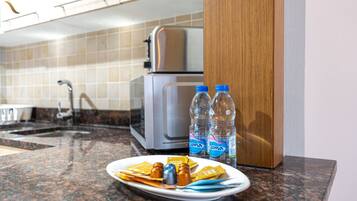 Een koffiezetapparaat/waterkoker, een koelkast, een magnetron, een oven