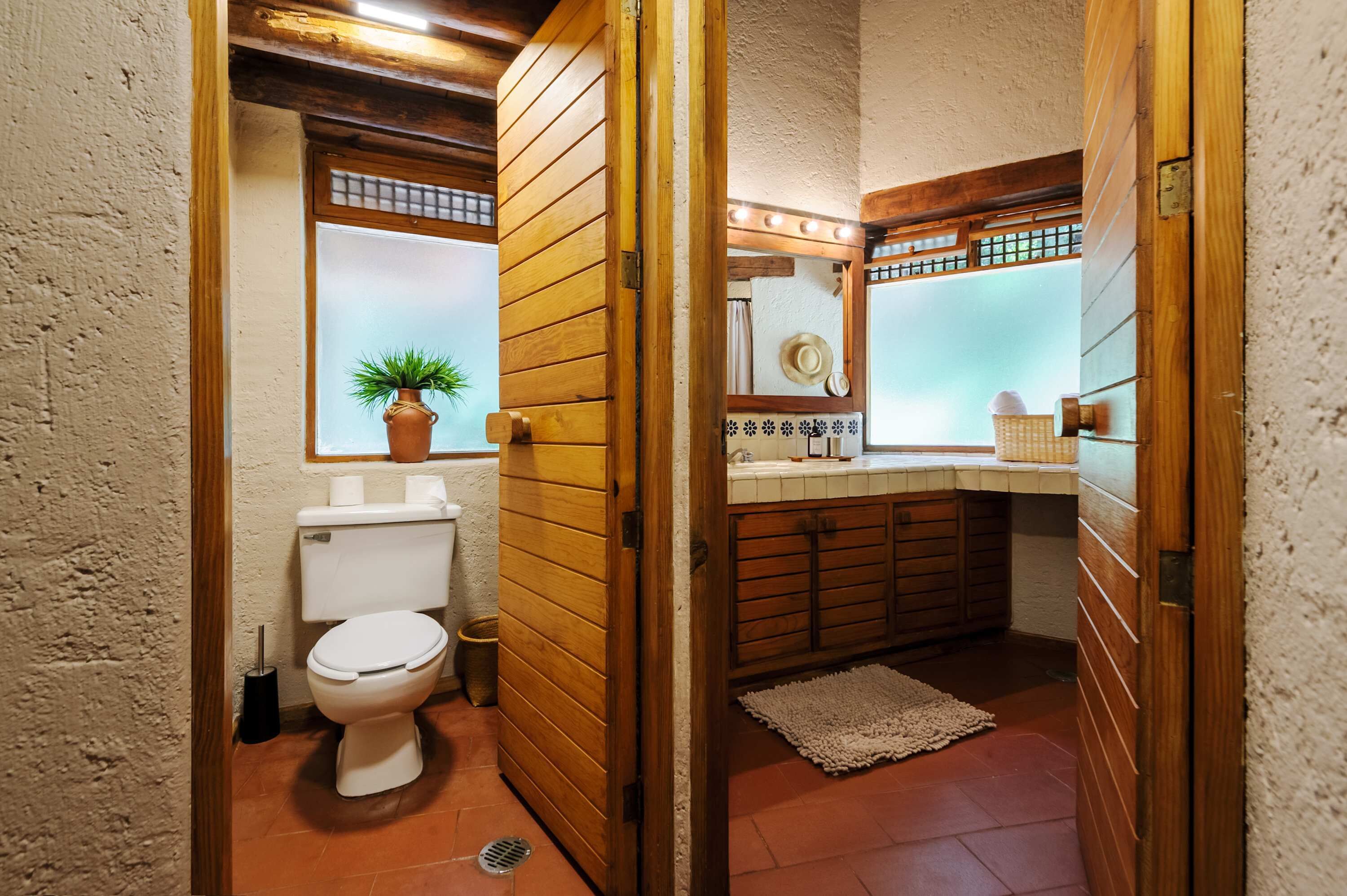 Een kleine badkamer met toilet, wastafel en spiegel.