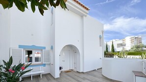 Ein modernes Gebäude mit weißer Fassade, einer Holzterrasse und Blick auf die Umgebung.