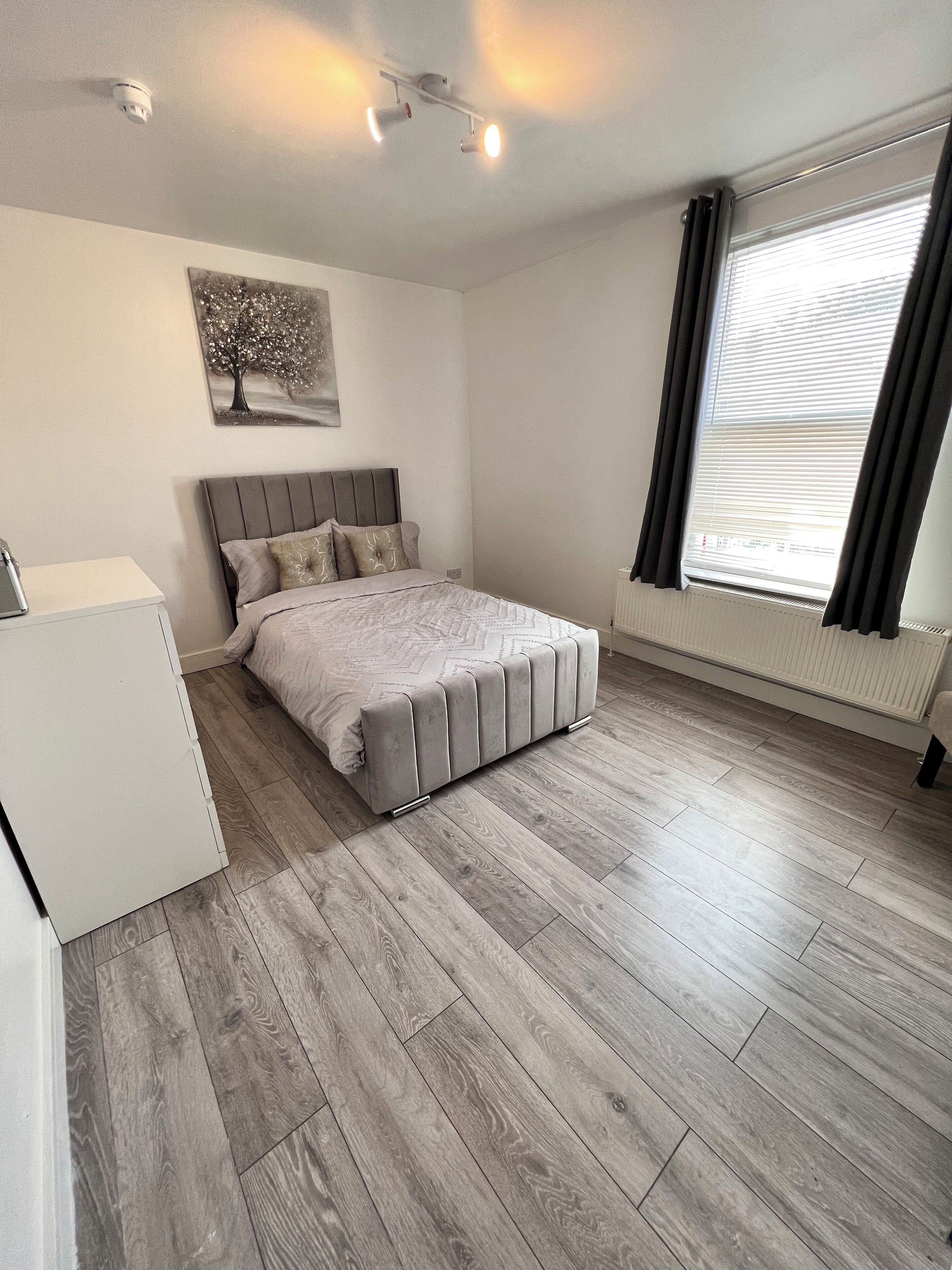 Une chambre à coucher avec un lit, un bureau et un radiateur.