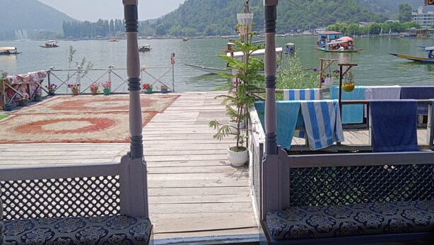 Una terraza de madera con vistas a un lago y barcos.