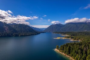 A large lake surrounded by mountains with clear skies.