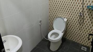 Un baño pequeño con inodoro, bidé y lavamanos.