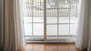 Ein Zimmer mit einer großen Schiebeglastür, die auf einen Balkon führt.