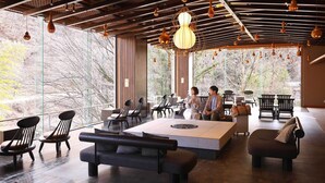 Un intérieur moderne avec une grande fenêtre, un plafond en bois et des luminaires suspendus.