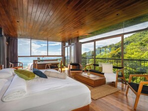 A spacious bedroom with a large bed, a desk, and a balcony with a scenic view. - The Riverston Grand (Rattota)