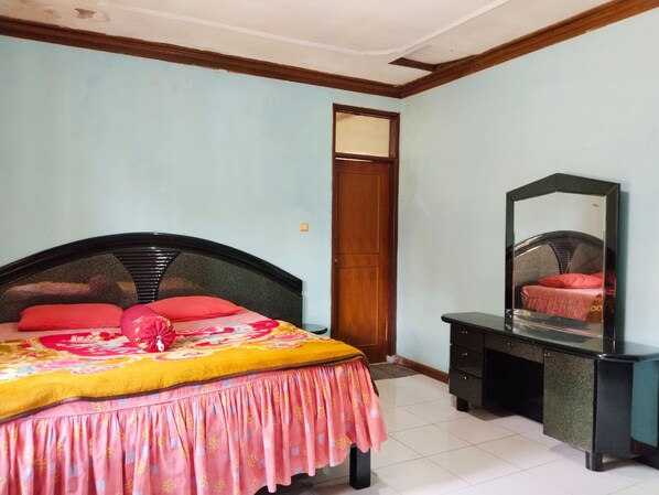 A bedroom with a bed, a dresser, and a door. - Villa Barkah 71 (Cisarua)