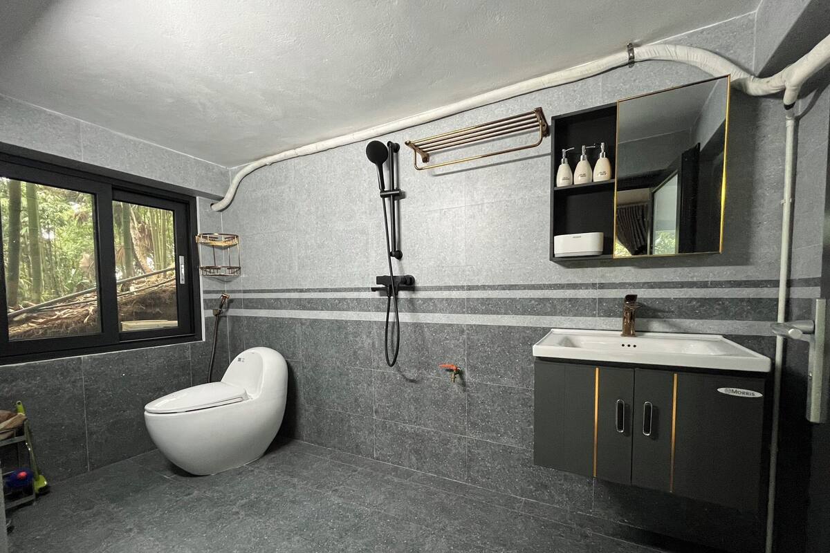 A modern bathroom with a toilet, shower, and sink.