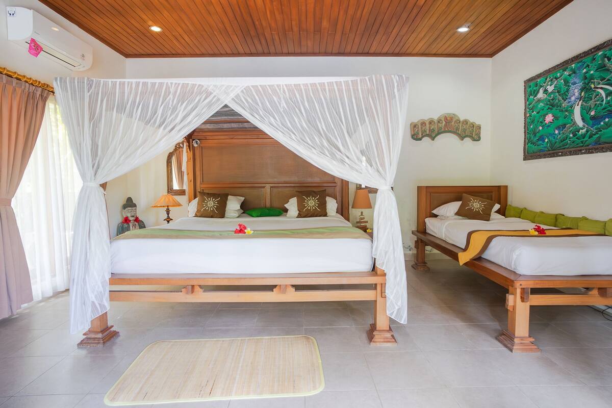 A bedroom with two beds, a wooden ceiling, and a large painting on the wall.