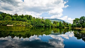 A serene river with a clear reflection of the sky and surrounding greenery. - Attractive chalet with sauna (Stadl an der mur)