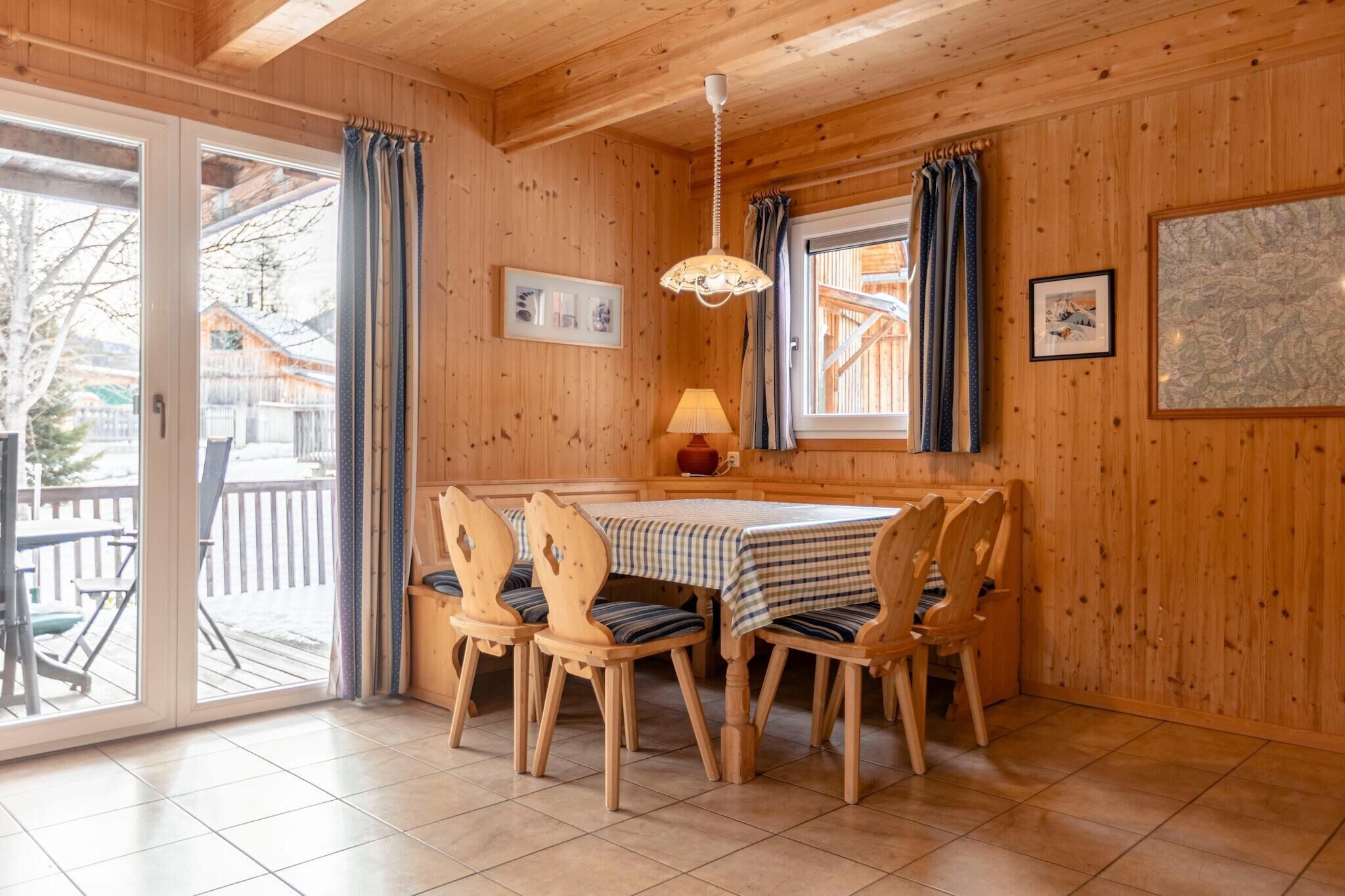Un intérieur en bois avec une table et des chaises, une lampe et une carte accrochée au mur.